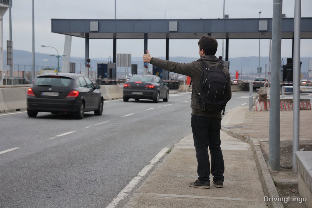 Explanada de una estación de peaje de autovía vista desde un coche, con vehículos en las cabinas
