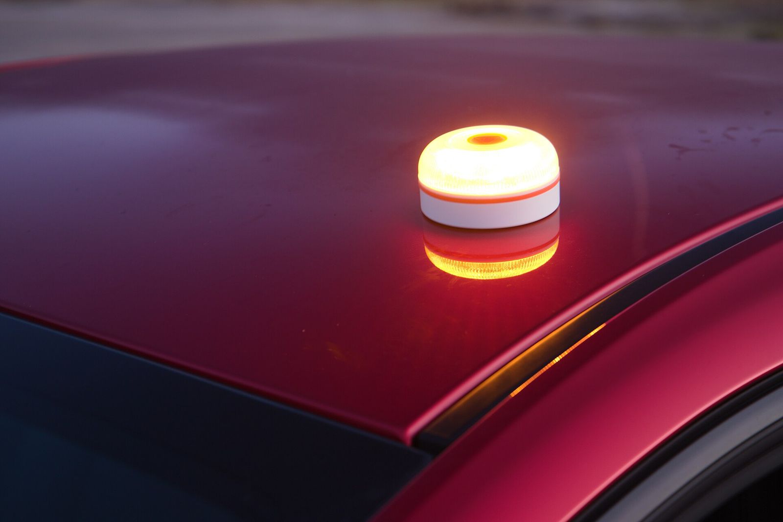 Dispositivo luminoso V-16 encendido sobre el techo de un turismo