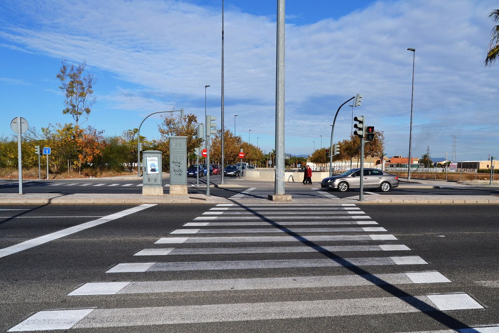 Paso de peatones tipo cebra en un cruce urbano con semáforos