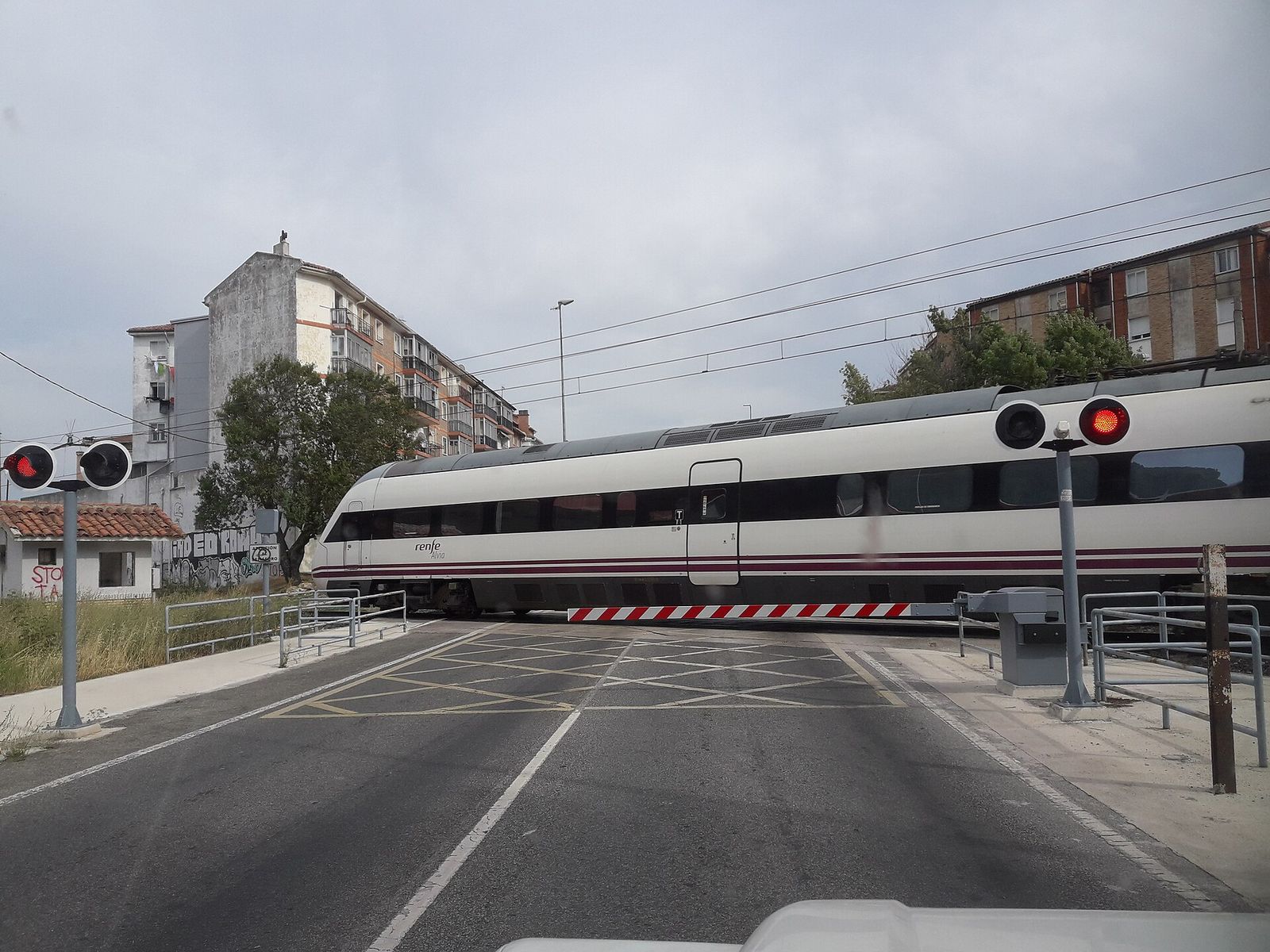 Paso a nivel con barreras bajadas y luces rojas encendidas al paso de un tren